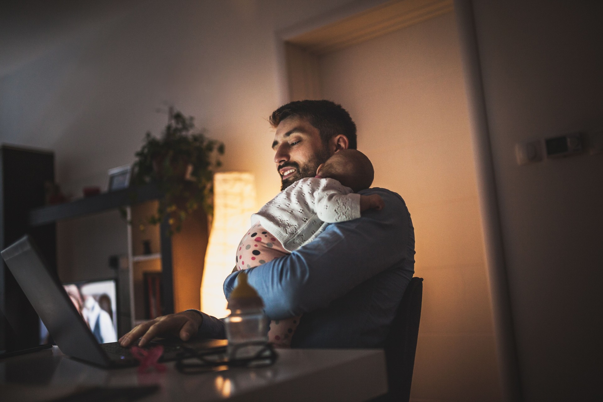 Young father working at home with his baby  girl